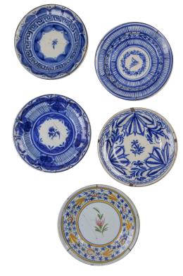 587.  Lote de cinco platos de cerámica esmaltada, cuatro de ellos en azul y blanco y otro con flor en el asiento.Manises y Levante, S. XIX.