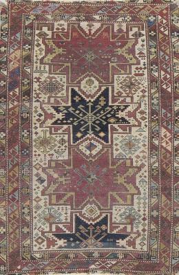 565.  Alfombra caucásica en lana de campo rojo y blanco, con motivos geométricos.