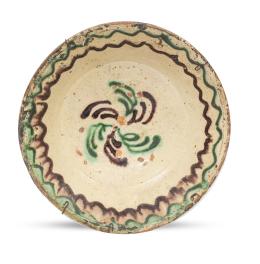 673.  Plato de cerámica esmaltada en verde y manganeso, decorado con flor girada.Teruel, S. XVIII.
