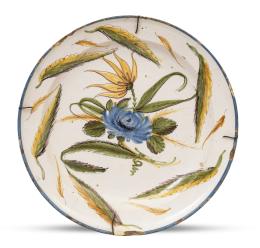 584.  Plato de cerámica esmaltada con una flor en azul y hojas en verde oliva.Ribesalbes, S. XIX.