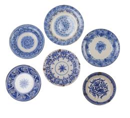 556.  Lote de seis platos de cerámica esmaltada en azul y blanco, alguno con decoración de flores y hojas.Manises, Onda y otras fabriquetas, S. XIX.