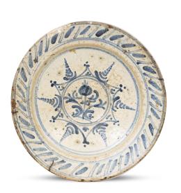 684.  Plato de cerámica esmaltada en azul y blanco con decoración geométrica en el alero y flor en una reserva.Teruel, (1751-1850).