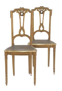 1317.  Pareja de sillas de estilo Luis XVI de madera tallada y dorada con asiento de rejilla.España, principios del S. XX.
