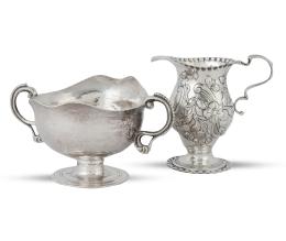 1365.  Lote de dos piezas de plata, formado por:Jarrita de plata repujada. Con marcas de Charles Stuart Harris, Londres, Inglaterra, 1899.Salsera de plata con asas. Con marcas de López, Madrid, S. XX.