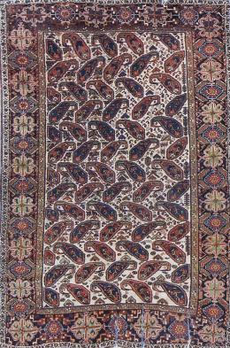 1143.  Alfombra en lana con decoración de "boteh", sobre campo blanco. Persia.