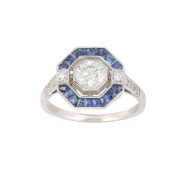 320.  Sortija estilo Art-Decó con brillante central de 0,65 ct aprox orlada de zafiros calibrados en marco octogonal y, flanqueado por brillantes