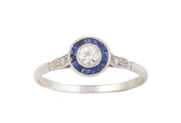 120.  Sortija ojo de perdiz con brillante central de 0,13 ct orlado de de zafiros calibrados