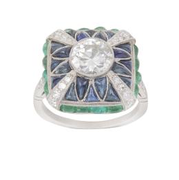 331.  Sortija estilo Art-Decó con brillante central de 1,32 ct, sobre marco bombée con zafiros gota de sebo, aspa de brillantes y marco de esmeraldas en gota de sebo