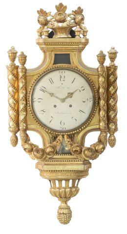 675.  Reloj de cartel de madera tallada, estucada y dorada. Firmado en la esfera: J. Lorning Stockholm.Trabajo sueco, finales del S. XIX.