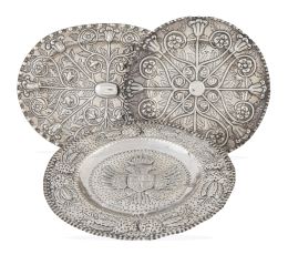 745.  Lote de tres bandejas de plata repujada formado por: una oval y una circular de ley 916, marcadas E. Otero; y otra circular historicista con águila bicéfala.S. XX, siguiendo modelos antiguos del S. XVI-XVII. 