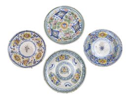 551.  Lote de cuatro platos de cerámica esmaltada decorados con soles, animales o arquitecturas.Manises, uno de la Fábrica de las Arenas, S. XIX.
