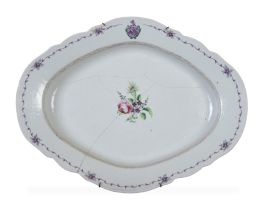 1169.  Bandeja oval de porcelana esmaltada con flores y un blasón.