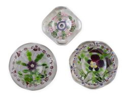 1319.  Lote de tres pisapapeles de cristal facetados: uno con penamiento, uno con flor morada y otro "millefiori".Baccarat, mediados del S. XIX.