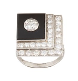 396.  Sortija cuadrada de ónix y brillantes en diseño asimétrico, con brillante principal de 0,50 ct aprox, enmarcado en ónix, y dos bandas de brillantes en "L"