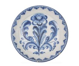 1200.  Plato acuencado de cerámica esmaltada en azul y blanco con la flor de la adormidera.Talavera, S. XVIII.
