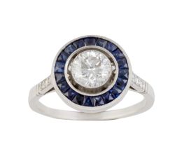 326.  Sortija de ojo de perdiz con brillante de 0,70 ct aprox central orlado de zafiros calibrados, con brillantes en los brazos de la montura