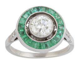 315.  Sortija ojo de perdiz de brillante central orlado de esmeraldas, con tríos de brillantes decorando los brazos de la montura