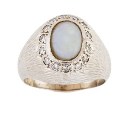 316.  Sortija años 60 con ópalo oval orlado de diamantes, en montura elevada con decoración grabada