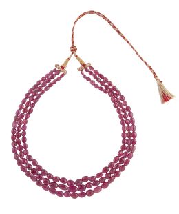 214.  Collar de tres hilos de rubíes en cuentas ovoides de tamaño creciente hacia el centro, que suman 750 ct aprox