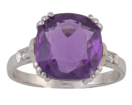 147.  Sortija con amatista central en talla cojín, flanqueda por diamantes en los brazos de la montura