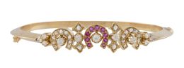 49.  Pulsera rígida c.1930 de brillantes de talla antigua con centro de herraduras alternas con flores, la herradura central de rubíes