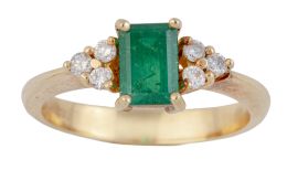 260.  Sortija con esmeralda de talla rectangular engastadas en garras, flanqueada por tríos de brillantes.