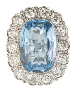 112.  Sortija c. 1920 con piedra azul central enmarcada en montura lobulada con brillantes de talla antigua