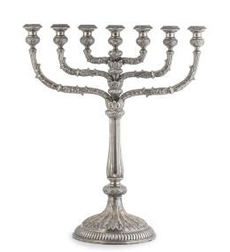 627.  Menorá o candelabro judío de plata en su color, moldeado, cincelado y repujado, decorada con hojas y flores. Con marcas, ley "916".Córdoba, S. XVIII.