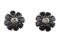 59.  Pendientes flor con ocho pétalos de zafiros de talla perilla rodeando a un brillante en chatón central