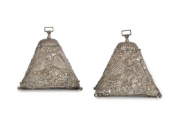 1106.  Pareja de estribos con alma de madera y plata, de decoración repujada con flores, roleos y dragón alado sustentando un escudo.Trabajo colonia, S. XIX..