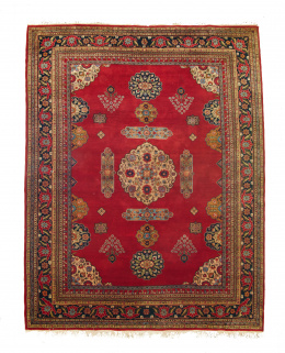 923.  Alfombra Tekke en lana con campo rojo y motivos de flores en cartuchos..