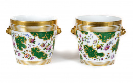 861.  Pareja de “cache-pots” de porcelana esmaltada, dorada a fuego y decorada con flores, rematada  a cada lado con cabezas de león.París, S. XIX.
