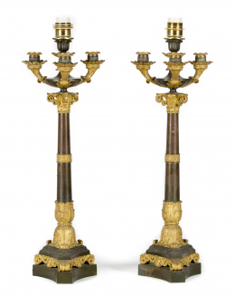 849.  Pareja de candelabros Carlos X de cuatro brazos luz de bronce dorado y pavonado, fuste con hojas de acanto y pies con hojas, con roleos y palmetas.Francia, h. 1830..