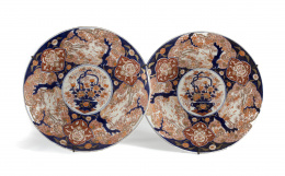1151.  Pareja de platos en porcelana Imari decorados con dos jarrones de flores.Japón, S. XIX