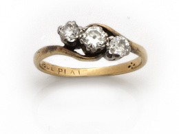 621.  Sortija de pp s. XX, tresillo, con línea oblicua de brillantes en montura de oro amarillo de 18K.