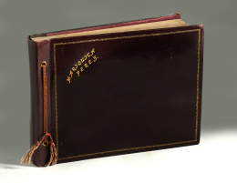 1084.  Álbum de fotos de Mariquita Pérez en piel, contiene: 16 fotos vestida con trajes regionales y 13 fotos esquiando, en pijama, vestida de primera comunión; posiblemente años 50..