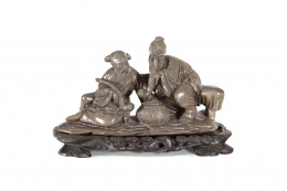 610.  Pareja de ancianos pescadores con pipa en piedra tallada sobre peana de madera.Trabajo chino, S. XX