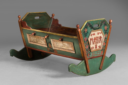 1011.  Cuna de madera tallada y policromada, con decoración de flores y emblema:  “IHS” y “María”  fechada en 1822.Trabajo austriaco, 1822..