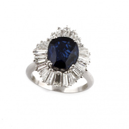 836.  Sortija con zafiro de 5 ct. aprox con intenso color rodeado por orla bailarina de trapecios de diamante color estimado F-G y grado de puerza VS, que suman 4,30 ct. aprox.