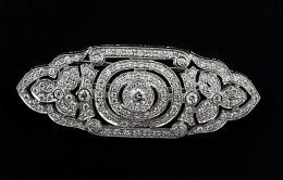 483.  Broche placa de estilo Art-Decó de brillante, con diseño de óvalos concéntricos flanqueados por hojas de brillantes y todo enmarcado por marco lobulado de brillantes