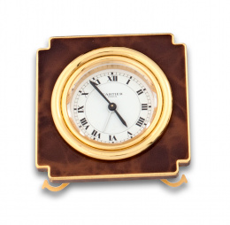 703.  Reloj de mesilla cartier con laca color tabaco y dorado.