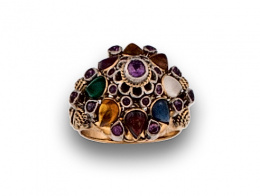 69.  Sortija oriental con piedras semipreciosas en forma rosetón elevado.