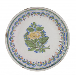 696.  Plato de cerámica levantina, esmaltada con una flor en el asiento.Manises. S. XIX.