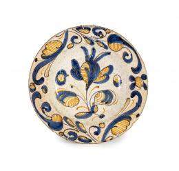 399.  Plato de cerámica esmaltada de la serie tricolor con una flor en el asiento y hojas en el alero.Talavera, S. XVII.