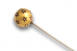 25.  Alfiler s.XIX en forma de esfera en oro de 18K con estrellas cuyo centro son diamantes talla rosa.