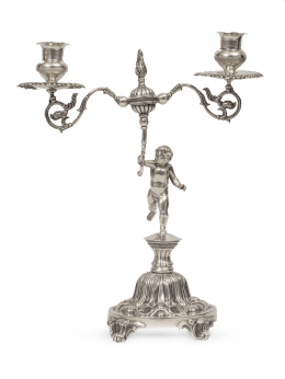 1150.  Candelabro de dos brazos de luz de plata de ley 915 con angelito, sigue modelos catalanes del S. XIX. Con marcas.Valentí, S. XX.
