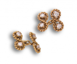 59.  Gemelos dobles con zirconitas en ochos de cordón rígido de oro amarillo de 18K .Sistema de cadena.