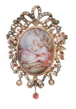 45.  Broche guardapelo S. XVIII-XIX con porcelana esmaltada con escena bucólica, en marco de perlitas con rubíes y esmeraldas