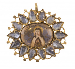 3.  Colgante S. XVII con miniatura de Santa Teresa en anverso y de Virgen en reverso, rodeado por marco de pétalos de cristal de roca, con fondo de azogue