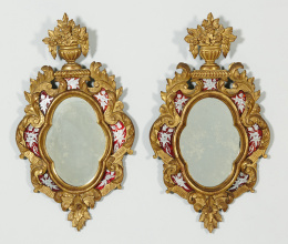 556.  Rara pareja de espejos Carlos III en madera tallada y dorada, “verre eglomisée” , plateado y rojo.La Granja, en el estilo veneciano, h. 1760.